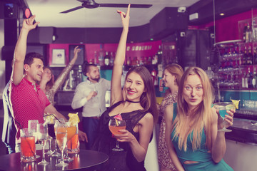Young students dancing on party with cocktails