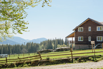 Wooden country house with fence in mountains. Beautiful landscape. Carpathians.