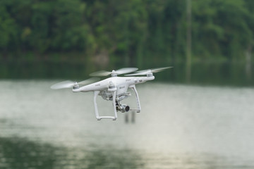 DJI Phantom 3 standard quad-copter flying into Royal Belum Rainforest National Park. Low angle view.