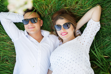 Happy couple woman and man lying on grass