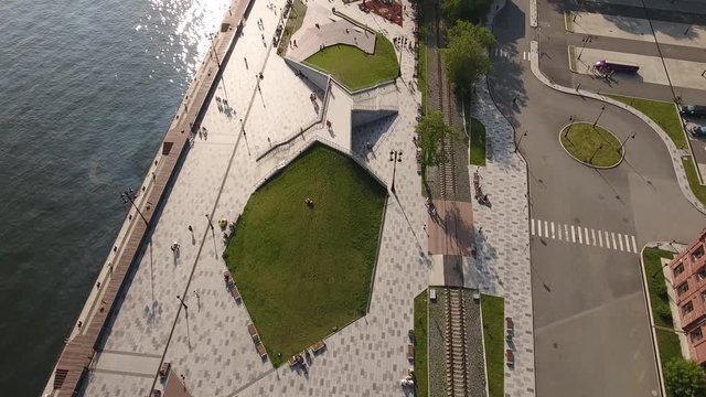 Great altitude helicopter flight above Tsesarevich Embankment park new Vladivostok recreation favorite people rest place people walk. Russia Primorsky krai. Golden horn bay. Summer warm sun.