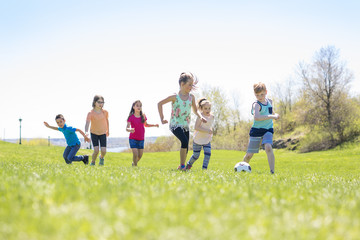 Fototapeta premium Boys and girls running towards football