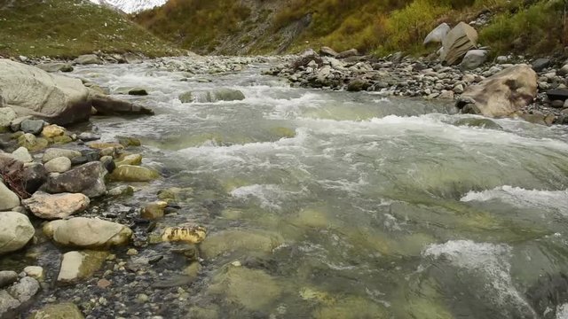 Amazing touristic place near river in mountain valley at the foot of Mt. Shkhara 5,193 m (17,040 ft). Upper Svaneti, Georgia, Europe. Caucasus mountains. HD video clip (High Definition).
