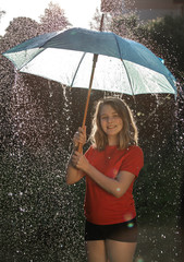 Happy girl under an umbrella in the rain
