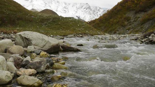 Amazing touristic place near river in mountain valley at the foot of Mt. Shkhara 5,193 m (17,040 ft). Upper Svaneti, Georgia, Europe. Caucasus mountains. HD video clip (High Definition).