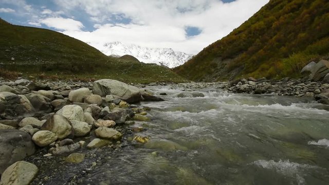 Amazing touristic place near river in mountain valley at the foot of Mt. Shkhara 5,193 m (17,040 ft). Upper Svaneti, Georgia, Europe. Caucasus mountains. HD video clip (High Definition).