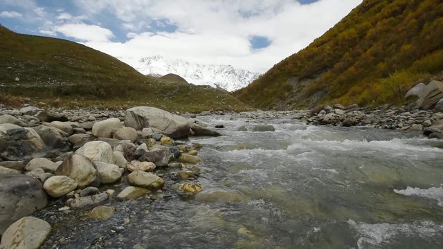 Amazing touristic place near river in mountain valley at the foot of Mt. Shkhara 5,193 m (17,040 ft). Upper Svaneti, Georgia, Europe. Caucasus mountains. HD video clip (High Definition).