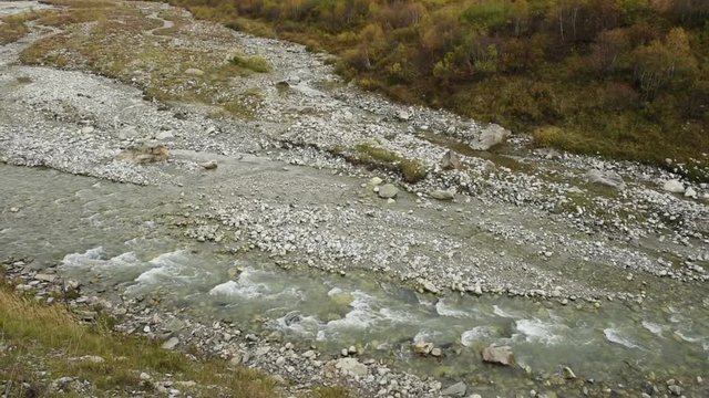 Amazing touristic place near river in mountain valley at the foot of Mt. Shkhara 5,193 m (17,040 ft). Upper Svaneti, Georgia, Europe. Caucasus mountains. HD video clip (High Definition).