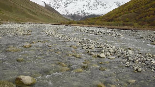 Amazing touristic place near river in mountain valley at the foot of Mt. Shkhara 5,193 m (17,040 ft). Upper Svaneti, Georgia, Europe. Caucasus mountains. HD video clip (High Definition).
