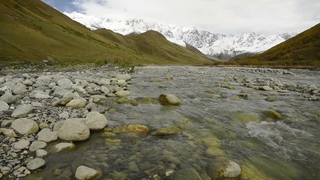 Amazing touristic place near river in mountain valley at the foot of Mt. Shkhara 5,193 m (17,040 ft). Upper Svaneti, Georgia, Europe. Caucasus mountains. HD video clip (High Definition).