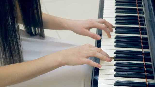 The close-up of the pianist's hands playing the piano. Steadicam. 4K.