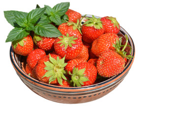Strawberry and sprig of mint in a clay bowl on an isolated background