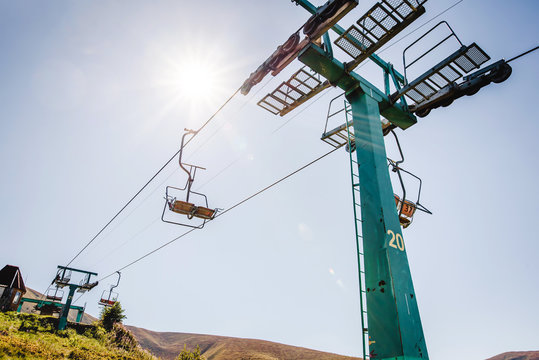 Ski lift with blue sky and sun on the background