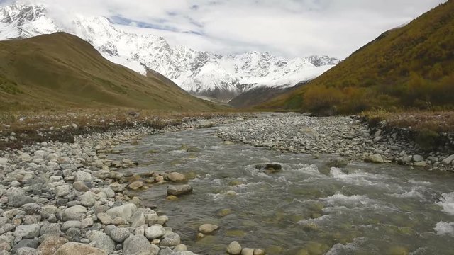 Amazing touristic place near river in mountain valley at the foot of Mt. Shkhara 5,193 m (17,040 ft). Upper Svaneti, Georgia, Europe. Caucasus mountains. HD video clip (High Definition).