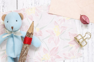 Flat lay stock photography flower pattern message letter paper blue bear holding wood pencil gold clip