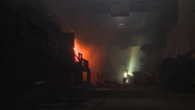 Workers on steel plant operates with molten metal. Copper plant
