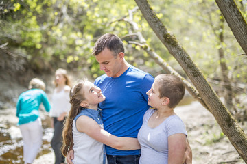 Happy young father with daughters outdoors