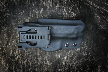 Handmade kydex holster for pistol on a grungy wood table
