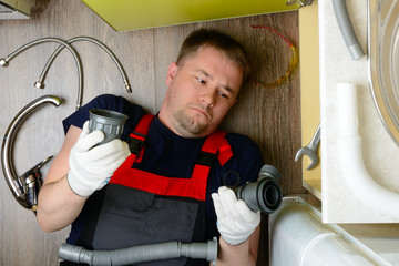 Plumber in the kitchen can not do plumbing: top view