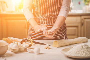 Woman bake pies. Confectioner makes desserts. Making buns. Dough on the table. Knead the dough.