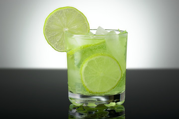A glass of Mojito with ice, lime wedges and mint