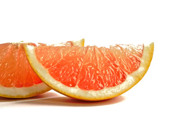 Closeup of grapefruit wedges on a white background