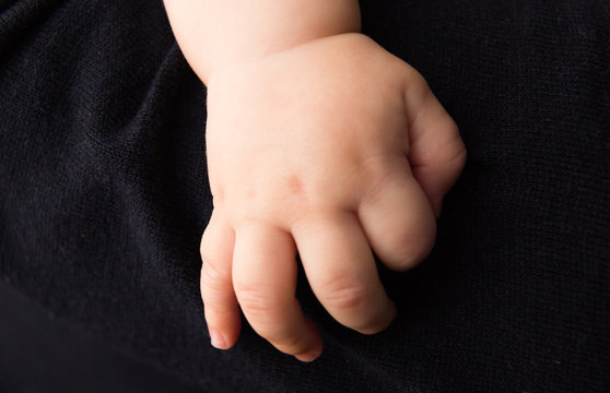 hand newborn on dark background