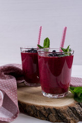 Blueberry smoothie with a straw and sprig of mint