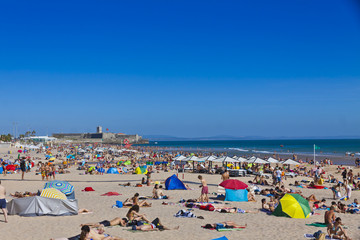 Crowded Atlantic Ocean beach in Lisbon, Portugal