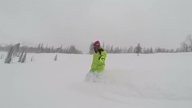 Snowboarder girl rides in powder snow