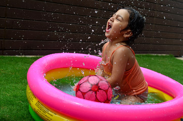 A girl enjoying in a water pool on a hot summer day!