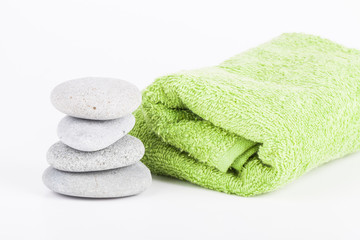 Fototapeta na wymiar Pebble gray stones and terry towel for spa procedure. Selective focus. Shallow depth of field