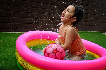 A girl enjoying in a water pool on a hot summer day!