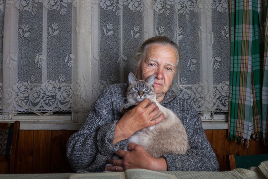 Elderly Woman With Cat In Rustic Interior