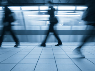 Subway train leaving station. People coming to or leaving the platform. Motion blur. Cyanotype effect.