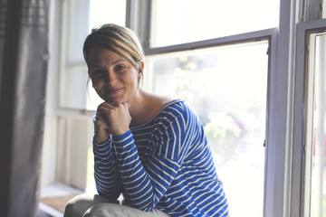 Beautiful young woman sitting near window