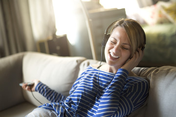 woman sitting on the couch take some good time with music headphone,