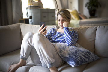 Obraz premium woman sitting on the couch take some good time with cellphone