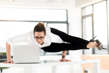 Smiling flexible woman watching at laptop
