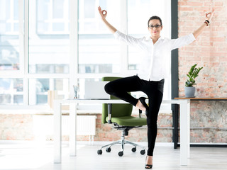 Smiling female doing gymnastics at work