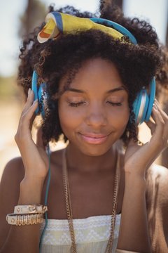 Close of young woman with eyes closed listening music