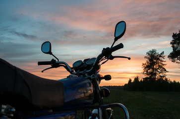 Handlebar motorcycle close-up on sunset background,