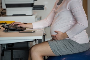 Pregnant businesswoman working in office