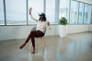 Female executive using virtual reality headset in office