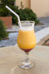 yellow and red tropical cocktail on a hot summer day