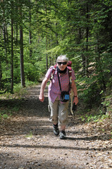 eine frau wandert auf einem steilen waldweg 