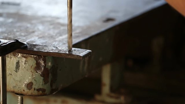 Drilling machine making a hole in a steel bar