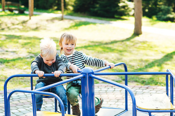 Obraz premium Two happy boys playing on playground in a park.