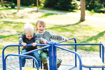 Fototapeta na wymiar Two happy boys playing on playground in a park.