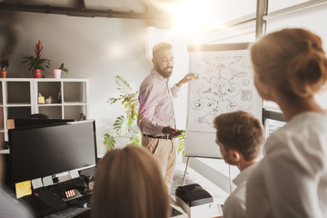 business team with scheme on flipboard at office